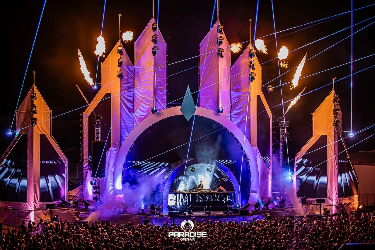 Festivalová scéna s veľkým oblúkom farebným svetlom a publikom